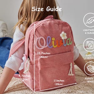 以下が含まれることがあります： カラフルな刺繍文字で「Olivia」と書かれ、白い花のアップリケが付いたピンクのコーデュロイ製バックパック。バッグのサイズは高さ40cm、幅28cm、奥行き12cmです。フロントポケットと白いロープのジッパープルが付いています。