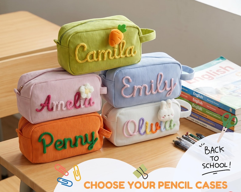 May include: Five rectangular corduroy pencil cases in green, pink, orange, light blue, and white. Each case features a personalized name in raised yarn lettering and a small plush icon, including a carrot, flower, and rabbit.