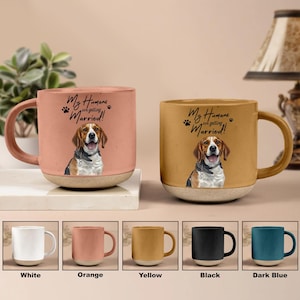 May include: Two ceramic mugs with a beagle illustration and the text "My Humans are getting Married!". The mugs are orange and yellow, with a light-colored base. Below are mugs in white, orange, yellow, black, and dark blue.