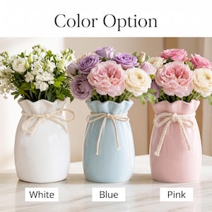 May include: Three ceramic vases in white, blue, and pink, each holding a bouquet of flowers. The vases have a ruffled top and a tied rope detail. The text "Color Option" is at the top, with "White", "Blue", and "Pink" below the vases.