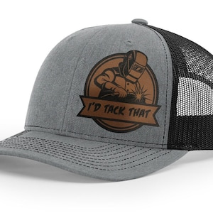 May include: A gray and black trucker hat with a brown leather patch featuring a welder and the text "I'd Tack That".