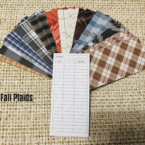 May include: A collection of fabric swatches featuring various plaid patterns in fall colors, including brown, red, blue, and white. The swatches are arranged in a fan shape and labeled "Fall Plaids". A blank inventory sheet with the headings "Category", "Date", and "Balance" is included.