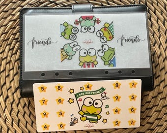 May include: Black vinyl binder with a clear pocket featuring cartoon frogs and the word "friends." A matching card with a frog illustration and numbers 4-9 is below. The card reads "1,000,000 Friends!"