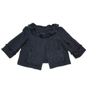 May include: A navy blue and white tweed jacket with a textured pattern. The jacket has three-quarter sleeves and a ruffled collar. The edges of the sleeves and collar are fringed. The jacket is open in the front.