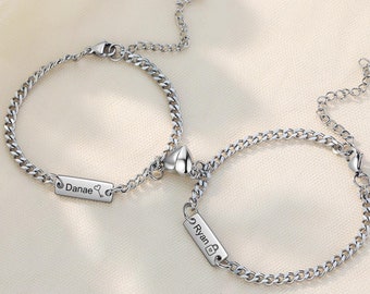 May include: Two silver chain bracelets with heart charms and personalized name tags that read "Danae" and "Ryan".
