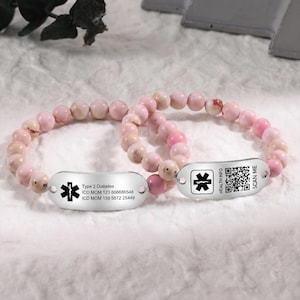 May include: Two beaded bracelets with pink and cream-coloured stones. Each bracelet features a silver tag with a medical symbol. One tag includes text: "Type 2 Diabetes" and medical codes. The other tag has a QR code and the words "Health Info" and "Scan Me."