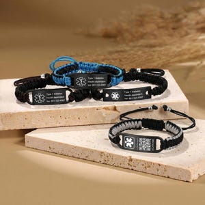 以下が含まれることがあります： 黒、青、グレーのメディカルアラートブレスレット。各ブレスレットは、医療シンボルとテキスト「Type 1 diabetes, Insulin dependent, Ice: 601-123-4567」または「Scan Me」が刻まれた黒い金属プレートを備えています。編み込みコードバンド。