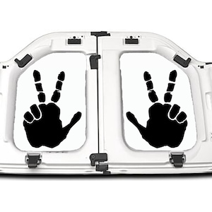 May include: White vehicle hood with two rectangular panels, each featuring a black hand silhouette making a peace sign. The hood is open, revealing the interior structure and hinges.
