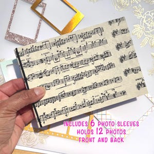 以下が含まれることがあります： 楽譜のデザインのフォトアルバム。アルバムには6つのフォトスリーブが含まれており、表裏合わせて12枚の写真が収納できます。金色のフォトフレームとキラキラ光るフォトフレームも写っています。