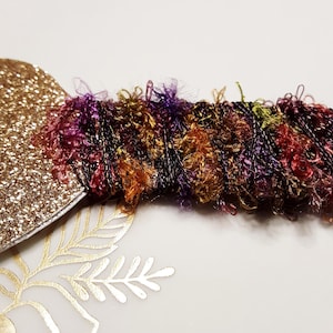 May include: A gold glitter heart with a colourful, fuzzy, multi-coloured yarn trim.