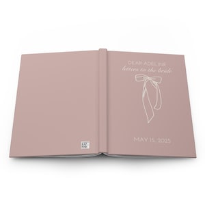 May include: A blush pink hardcover book with the title "Dear Adeline, letters to the bride" and a white bow illustration. The date "May 15, 2025" is printed below the illustration.