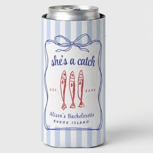 May include: A blue and white striped can cooler with a navy blue frame and bow design. The text "she's a catch" is above three red fish illustrations. Below the fish is the text "Alison's Bachelorette Rhode Island".
