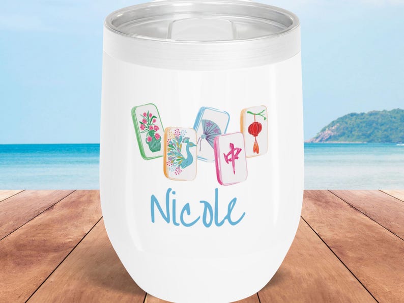 May include: White insulated wine tumbler with a silver rim, featuring a watercolor design of Mahjong tiles and the name "Nicole" in blue script. The tiles display various illustrations, including flowers, a bird, and Chinese characters.