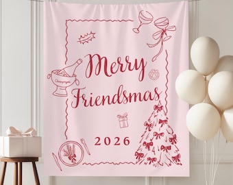 May include: A light pink fabric banner featuring dark red line art illustrations of a champagne bucket, wine glasses, a gift, a plate, and a Christmas tree. The text reads Merry Friendsmas 2026 in a cursive and block font style.