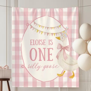 May include: A pink and white gingham backdrop with a banner that reads "Eloise is One silly goose." A cartoon goose wearing a party hat and bow is featured. White balloons and a gift box complete the scene.