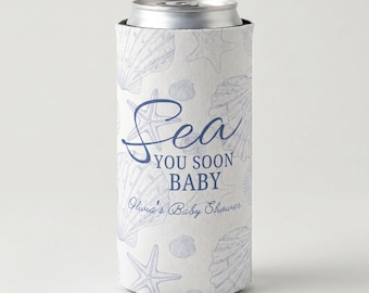 May include: A white can cooler with a blue seashell and starfish pattern. The text "Sea You Soon Baby" is displayed in blue script, with "Olivia's Baby Shower" below. The cooler is designed to keep beverages cold.