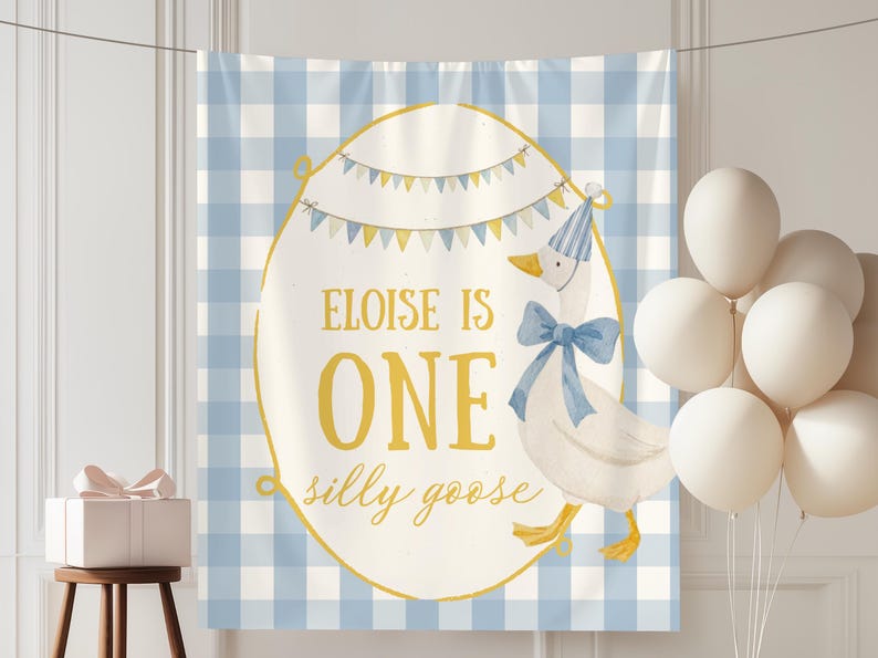 May include: A birthday banner with a blue and white gingham pattern background. The banner features a cartoon goose wearing a party hat and bow tie. Text on the banner reads "Eloise is One silly goose". White balloons and a gift box complete the party scene.