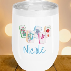 May include: White insulated tumbler with a silver rim and lid. The tumbler features a watercolor design of five Mahjong tiles and the name "Nicole" in blue script. The tiles have floral, bird, and Chinese symbol designs.