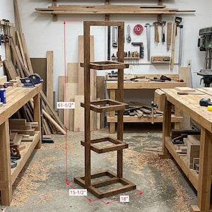 May include: A dark stained wooden plant stand. The stand is 156 cm tall, 39 cm wide, and 46 cm deep, featuring four square shelves. The design is modern and suitable for displaying plants or decorative items. The stand is made of wood.