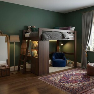 K&ouml;nnte beinhalten: Ein Hochbett aus dunklem Holz mit eingebautem Schreibtisch und Stauraum. Das Bett hat eine graue Bettdecke und Kissen. Unter dem Bett befindet sich ein blauer Sessel mit einem Teppich und B&uuml;chern. Der Raum hat dunkelgr&uuml;ne W&auml;nde und einen gemusterten Teppich.