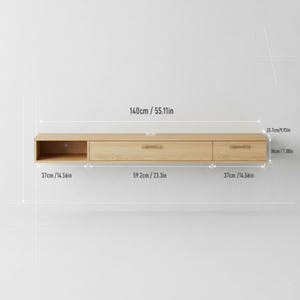 May include: A light-colored wooden floating media console with two drawers and an open compartment. The console is 55.11 inches long, 14.56 inches deep, and 7.08 inches high. It features a minimalist design with a simple, modern aesthetic.