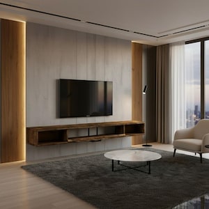 May include: A modern living room featuring a wall-mounted TV above a long, wooden floating shelf. The room includes a gray rug, a marble-topped coffee table, and a cream-colored armchair. The walls are a mix of wood and concrete.