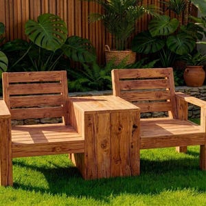 Puede incluir: Dos sillones de exterior de madera con una mesa auxiliar conectada. Los muebles son de madera marrón claro y tienen un diseño de respaldo de listones. Las sillas están colocadas sobre un césped verde, con exuberante vegetación y una valla de madera en el fondo.