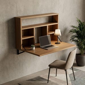May include: A wall-mounted wooden desk with a built-in bookshelf. The desk has a fold-down work surface, a laptop, a small lamp, and a potted plant. A chair sits in front of the desk. The desk is made of light-colored wood.