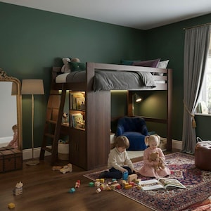 K&ouml;nnte beinhalten: Ein Hochbett aus dunklem Holz mit eingebautem B&uuml;cherregal und Schrank. Eine Leiter bietet Zugang zum Bett. Unter dem Bett befinden sich ein blauer Sessel und eine Leselampe. Zwei Kinder spielen auf einem gemusterten Teppich mit Holzbl&ouml;cken und einem Buch.
