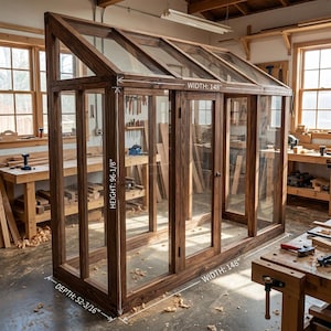 May include: A large, wooden greenhouse with glass panels and a slanted roof. The structure is stained a dark brown and has dimensions of 148 inches wide, 96-1/8 inches high, and 52-3/16 inches deep. The greenhouse is in a workshop setting.