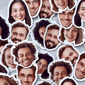 Könnte beinhalten: Eine Sammlung von Aufklebern mit lächelnden Gesichtern verschiedener Personen. Die Aufkleber sind um Kopf und Schultern ausgeschnitten, mit unterschiedlichen Hauttönen, Frisuren und Gesichtsausdrücken. Einige tragen Brillen. Der Hintergrund ist ein hellgrauer Stoff.