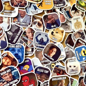 Op de afbeelding: Een verzameling kleurrijke stickers met verschillende afbeeldingen en tekst. De stickers bevatten memes, stripfiguren en gezichten van beroemdheden. Tekst bevat zinnen als "Bravo", "Geniaal" en "Mega". De stickers liggen op een lichtbruin oppervlak.