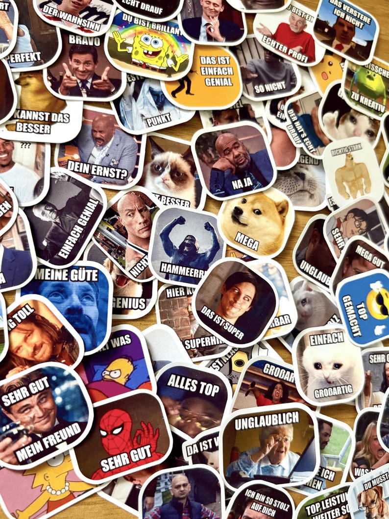 Op de afbeelding: Een verzameling kleurrijke stickers met verschillende afbeeldingen en tekst. De stickers bevatten memes, stripfiguren en gezichten van beroemdheden. Tekst bevat zinnen als "Bravo", "Geniaal" en "Mega". De stickers liggen op een lichtbruin oppervlak.