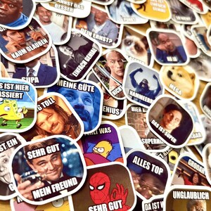 Op de afbeelding: Een verzameling meme-stickers met afbeeldingen van beroemdheden en stripfiguren. De stickers hebben witte randen en bevatten Duitse tekst, zoals "SEHR GUT" en "MEIN FREUND". De stickers zijn in verschillende vormen en maten.