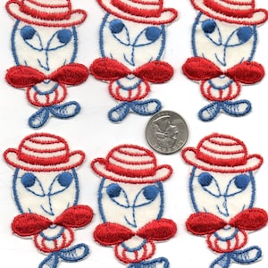 May include: Six embroidered iron-on patches featuring a cartoon character wearing a red and white striped hat, a red bow tie, and blue eyes. The character is white with red and blue accents.