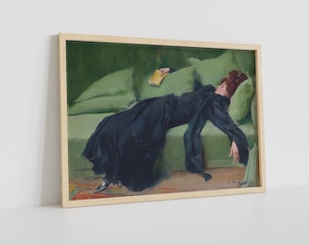 May include: A painting of a woman in a black dress lying on a green couch. She is holding a book in her hand and her eyes are closed. The painting is framed in a light wood frame.