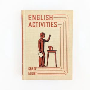 K&ouml;nnte beinhalten: Vintage "English Activities" Lehrbuch f&uuml;r die achte Klasse. Das Cover zeigt eine rote Illustration einer Person, die zeigt, mit einem kleinen Tisch und einem Krug. Titel und Klassenstufe sind in roter Schrift.