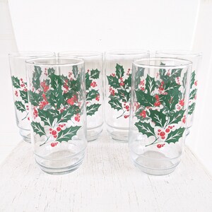 May include: Set of six clear glass drinking glasses with a green holly and red berry design.