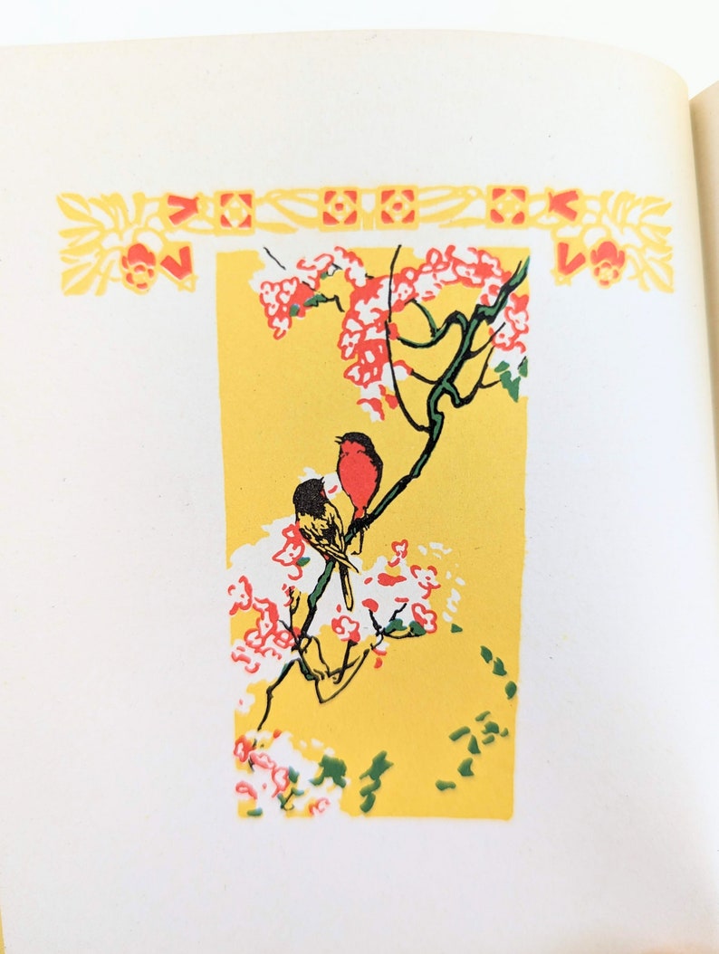 Pode incluir: Um fundo amarelo com um ramo de &aacute;rvore estilizado com flores vermelhas e brancas. Dois p&aacute;ssaros est&atilde;o empoleirados no ramo, um vermelho e outro amarelo. A imagem &eacute; emoldurada com uma borda decorativa.