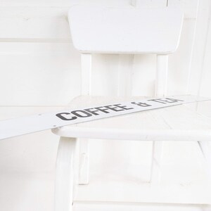 Puede incluir: Silla de madera blanca con un letrero blanco que dice "COFFEE & TEA" en la parte superior.