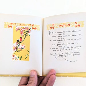 Pode incluir: Um livro aberto com p&aacute;ginas amarelas e uma ilustra&ccedil;&atilde;o colorida de p&aacute;ssaros em um galho. O texto na p&aacute;gina diz "&Eacute; uma palavra maravilhosa quando voc&ecirc; a ouve de um velho amigo de verdade que &eacute; verdadeiro como a agulha para o p&oacute;lo &eacute;, ou perto dele; &Eacute; &oacute;timo quando ele a ouve de voc&ecirc;. Tem toda a alegria e o esplendor A can&ccedil;&atilde;o dos p&aacute;ssaros tem, voc&ecirc; sabe. &Eacute; alegre, &eacute; alegre, &eacute; terno, Essa sauda&ccedil;&atilde;o de amigo para amigo, "OL&Aacute;!" "
