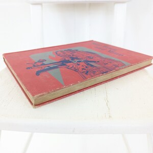 May include: A red hardcover book with the title "The Story of Mrs. Tubbs" printed in blue on the cover. The cover features an illustration of people walking down a street.