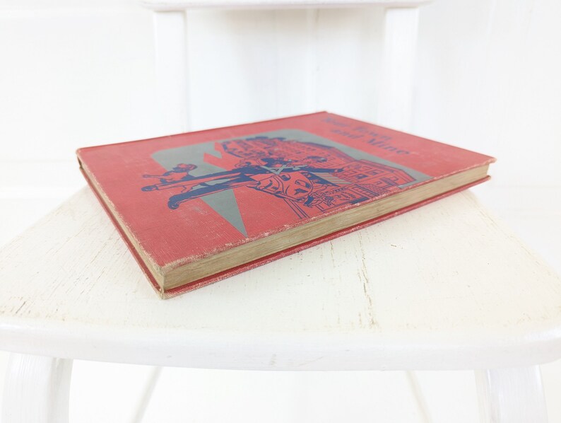 May include: A red hardcover book with the title "The Story of Mrs. Tubbs" printed in blue on the cover. The cover features an illustration of people walking down a street.