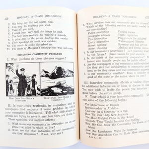 K&ouml;nnte beinhalten: Offenes Buch mit Text und Illustrationen. Seite 476 zeigt eine Diskussion &uuml;ber Gemeinschaftsprobleme mit Fragen und Bildern. Seite 477 setzt die Diskussion mit weiteren Fragen fort. Das Buch hat ein rot-cremefarbenes Farbschema.