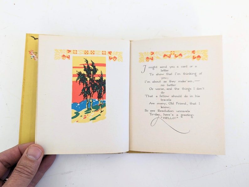Pode incluir: Um livro aberto com uma capa amarela e uma ilustra&ccedil;&atilde;o colorida de &aacute;rvores na p&aacute;gina da esquerda. A p&aacute;gina da direita tem um poema escrito &agrave; m&atilde;o sobre o envio de um cart&atilde;o ou uma carta a um amigo. O poema diz: "Eu poderia enviar-lhe um cart&atilde;o ou uma carta para mostrar-lhe que estou a pensar em si. Sou como s&atilde;o feitos. - n&atilde;o melhor nem pior, e as coisas que n&atilde;o fa&ccedil;o que um homem deveria fazer nas suas viagens s&atilde;o muitas. Velho amigo, eu sei. Ent&atilde;o, antes que a resolu&ccedil;&atilde;o se desfa&ccedil;a, aqui est&aacute; uma sauda&ccedil;&atilde;o: OL&Aacute;!"