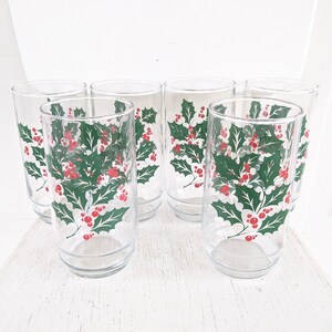 May include: Set of six clear glass drinking glasses with a holly and berry design. The glasses are perfect for holiday entertaining.