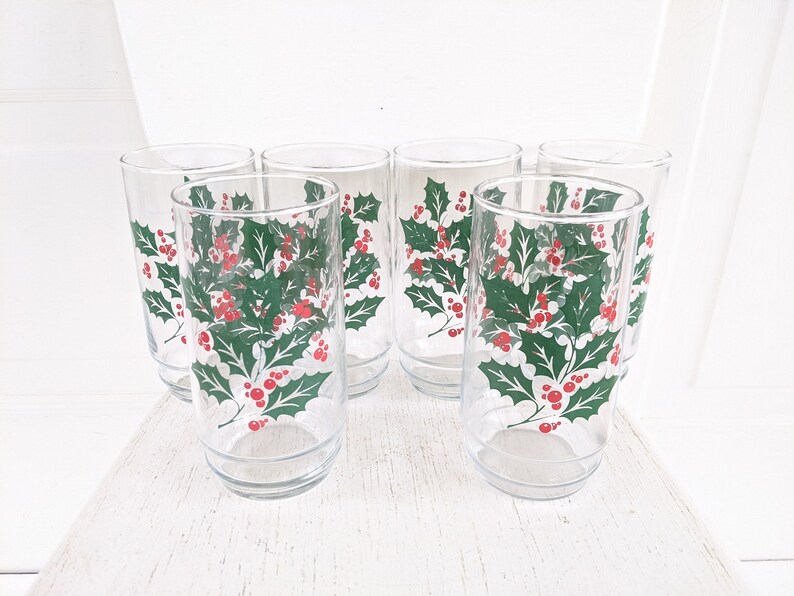 May include: Set of six clear glass drinking glasses with a holly and berry design. The glasses are perfect for holiday entertaining.