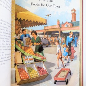 May include: A colorful illustration of a bustling outdoor market with a red wagon, fruit stands, and people walking by. The sign above the market reads "CITY MARKET".