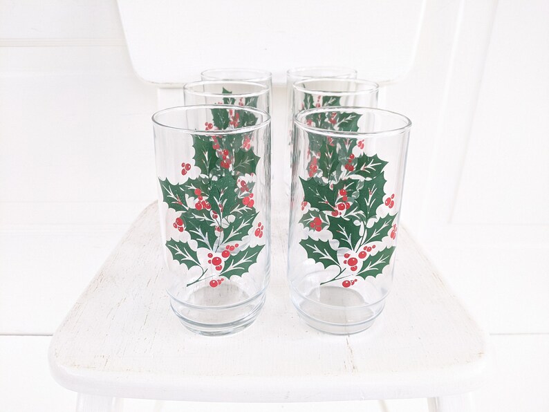 May include: Set of six clear glass drinking glasses with a holly and berry design. The glasses are perfect for holiday entertaining.
