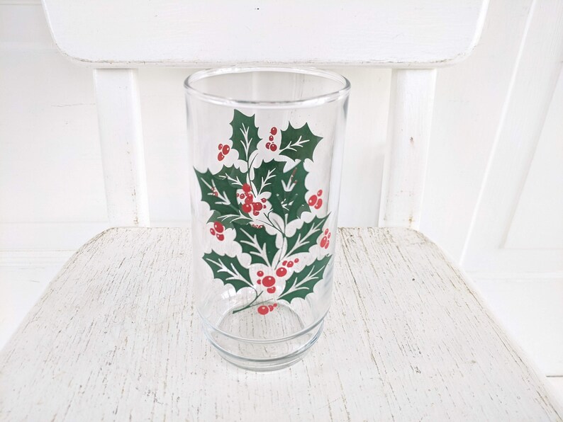 May include: A clear glass tumbler with a green holly and red berry design.